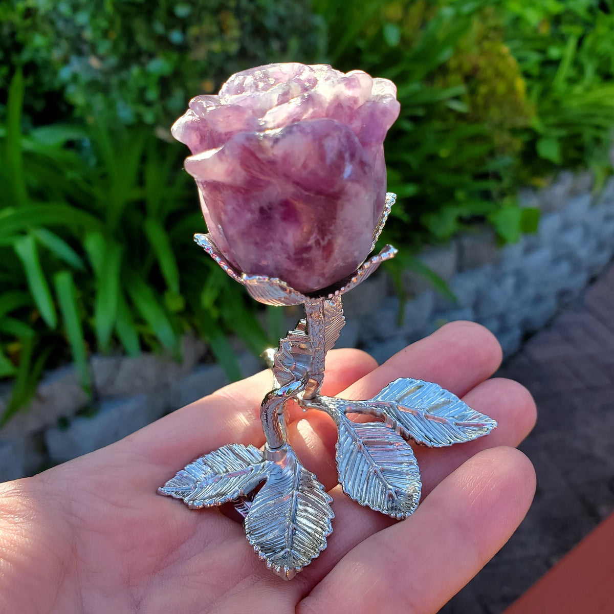 May include: A purple amethyst rose carved from crystal and set on a silver metal stem with leaves.