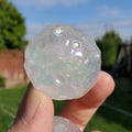 May include: A clear iridescent glass sphere with a textured surface and small air bubbles trapped inside.